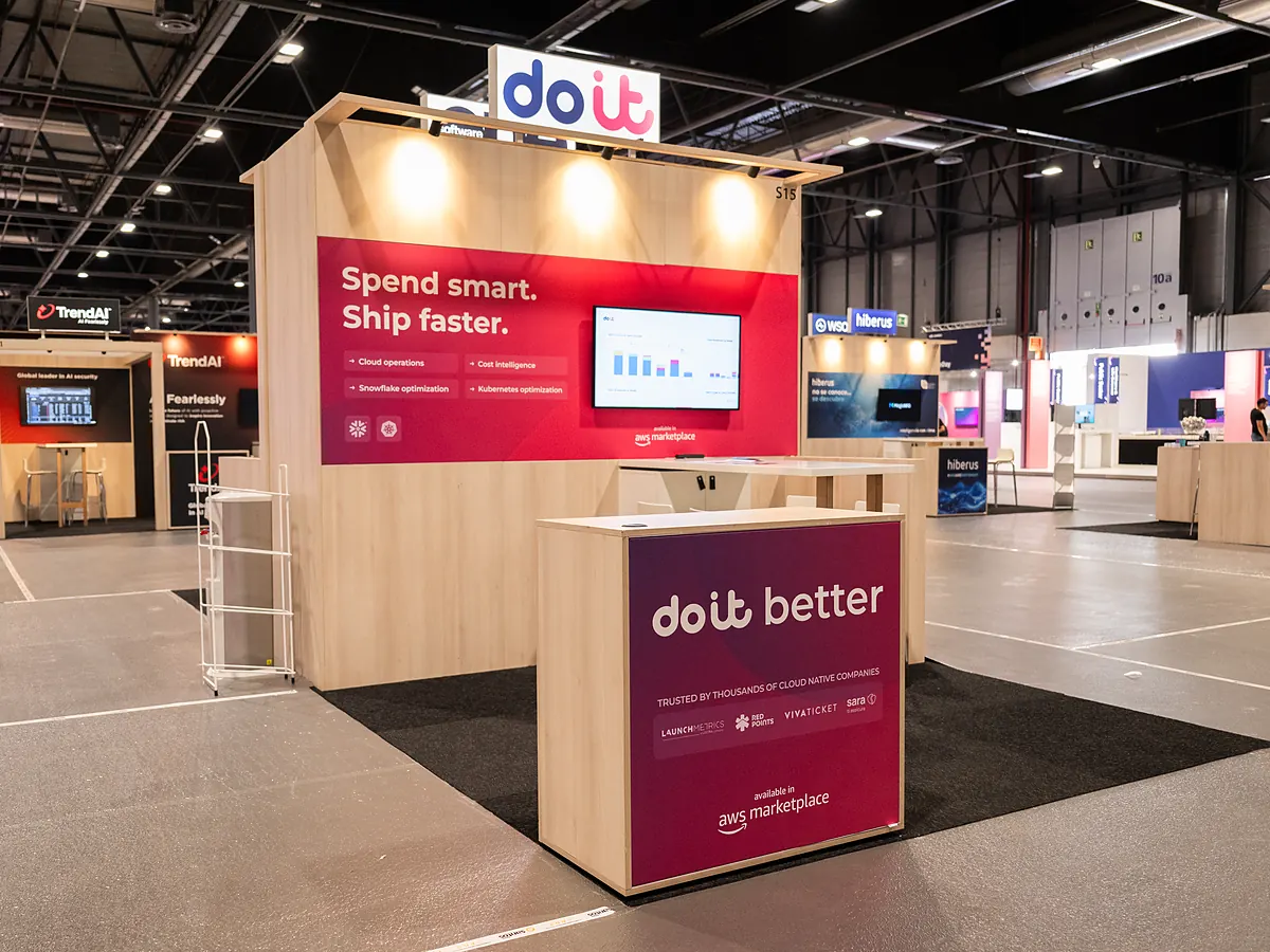 Stand van DoiT van de andere kant, met de rode printwand, het scherm en de balie met logo