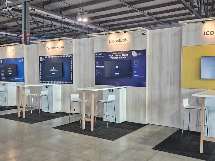 Rij gekoppelde stands van onder andere GlobalDots en iconsulting, elk met een eigen printwand, scherm en statafel