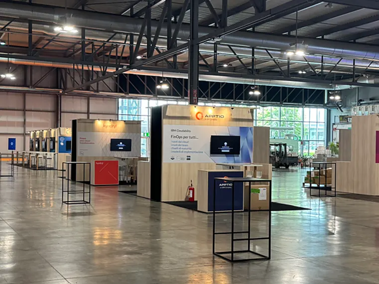 Overzicht van een beurshal met rijen gekoppelde stands met printwanden en schermen