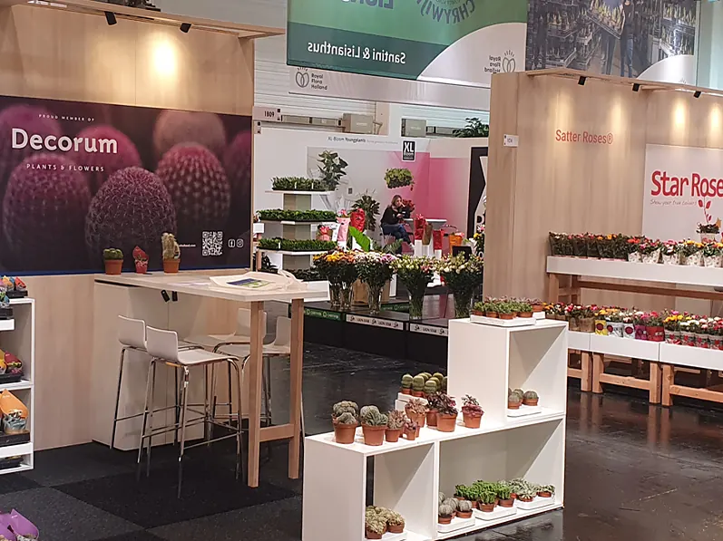 Stands van Decorum en Star Roses met plantenstellingen en bloemen op de beursvloer